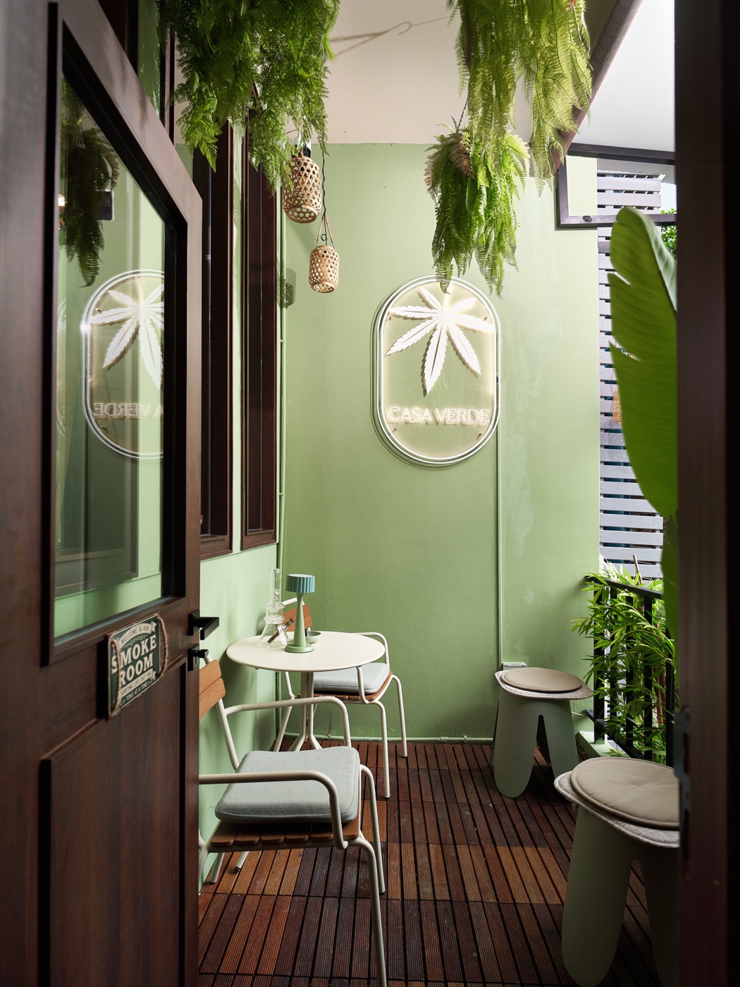 The sage terrace with hanging ferns and white chairs
