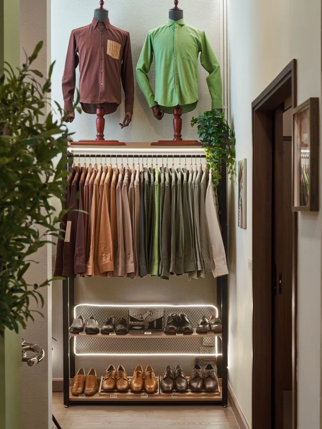 The boutique rail of earth-tone shirts with leather shoes below
