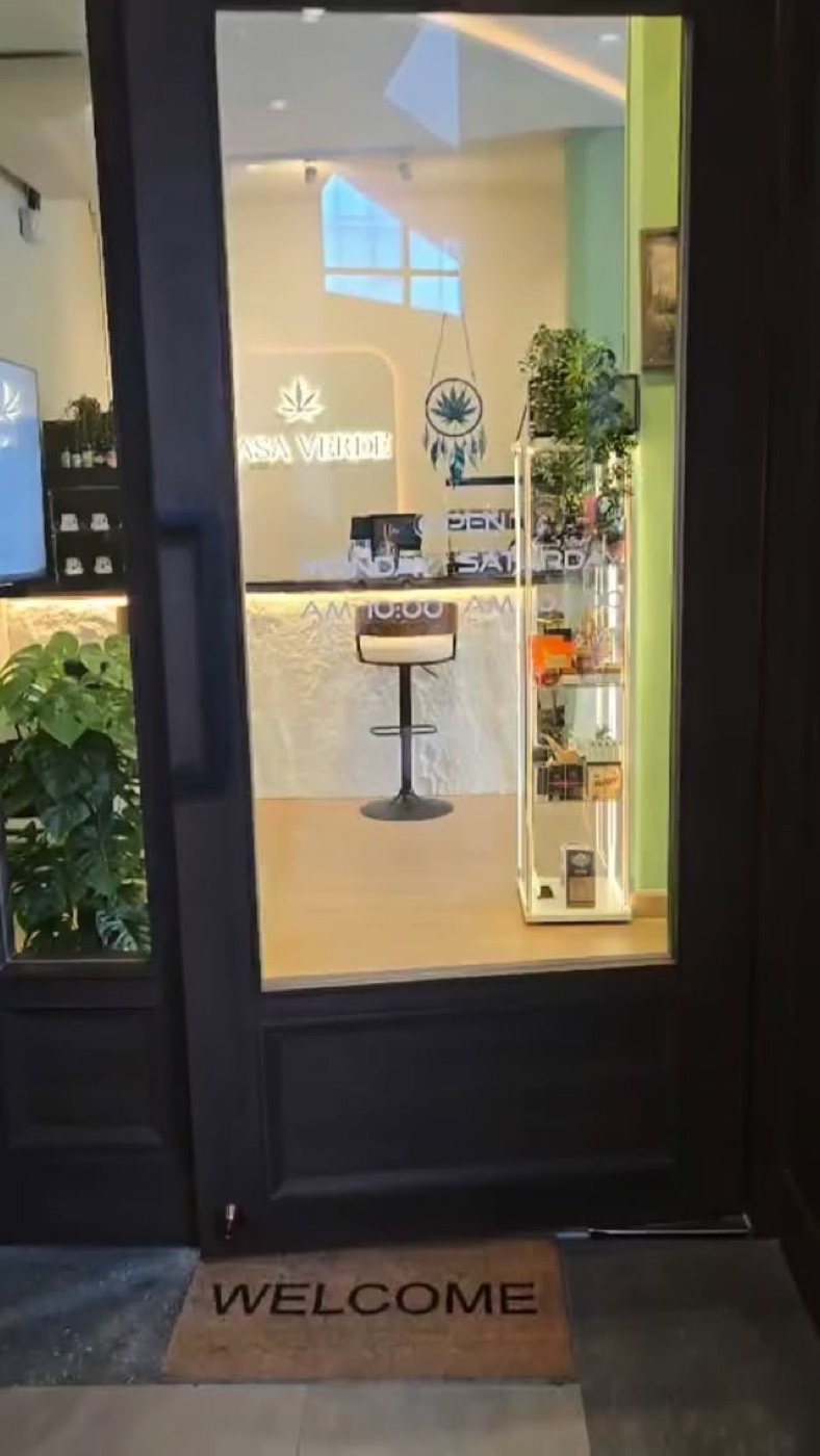 The open door with the lit leaf sign behind